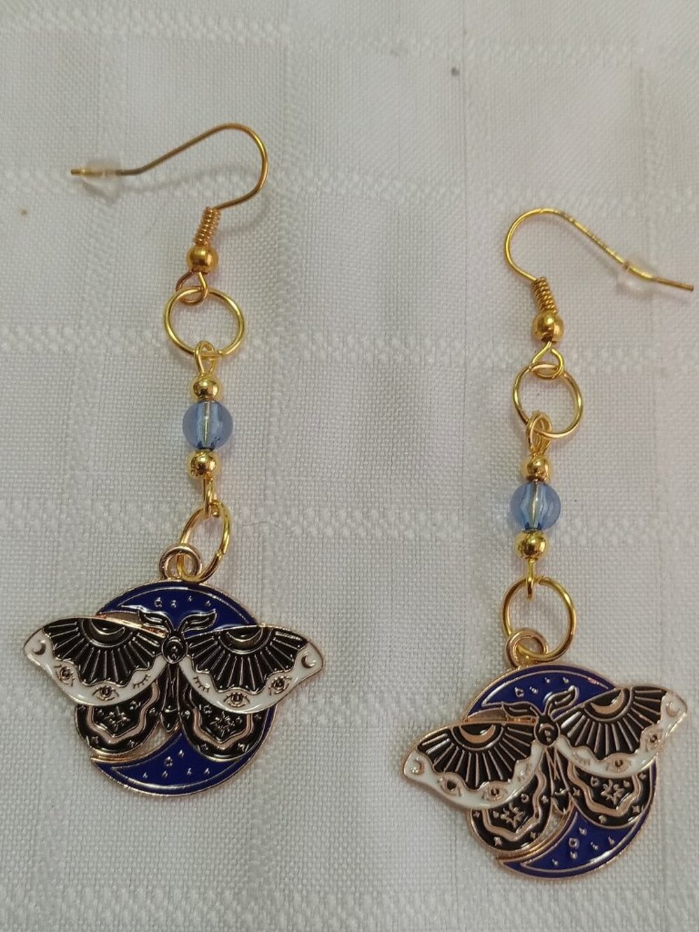 Handmade gold-colored earrings with multicolored enameled butterflies and beads